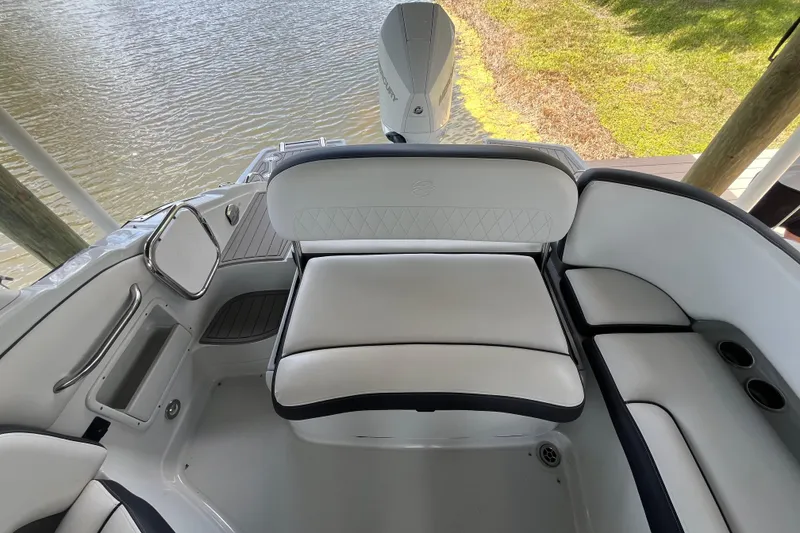 Slide: The Image of 2022 Crownline 260 XSS boat interior with white seating and water view. - 14