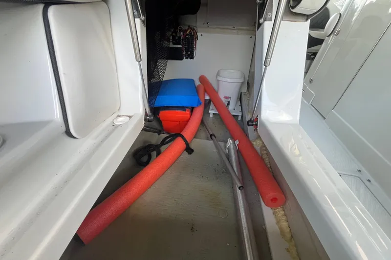 Slide: The Image of Interior storage area of 2022 Crownline 260 XSS boat with pool noodles and equipment. - 21