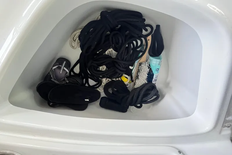 Slide: The Image of Storage compartment in 2022 Crownline 260 XSS boat with ropes and accessories. - 28
