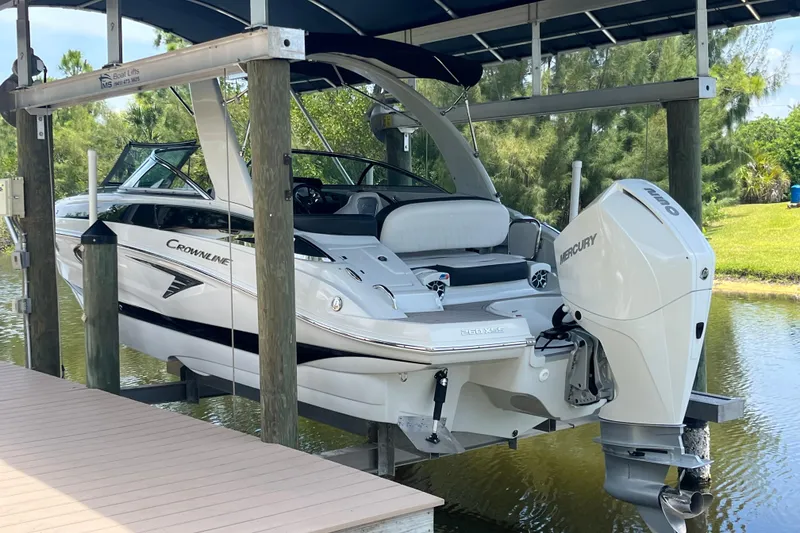 Slide: The Image of 2022 Crownline 260 XSS boat on lift, featuring sleek design and powerful Mercury engine. - 3