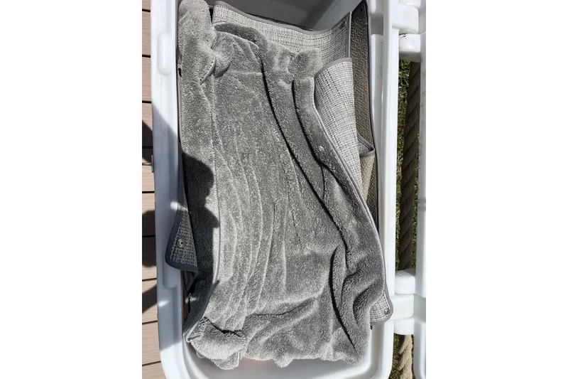 Slide: The Image of Gray towel in a storage compartment of a 2022 Crownline 260 XSS boat. - 33