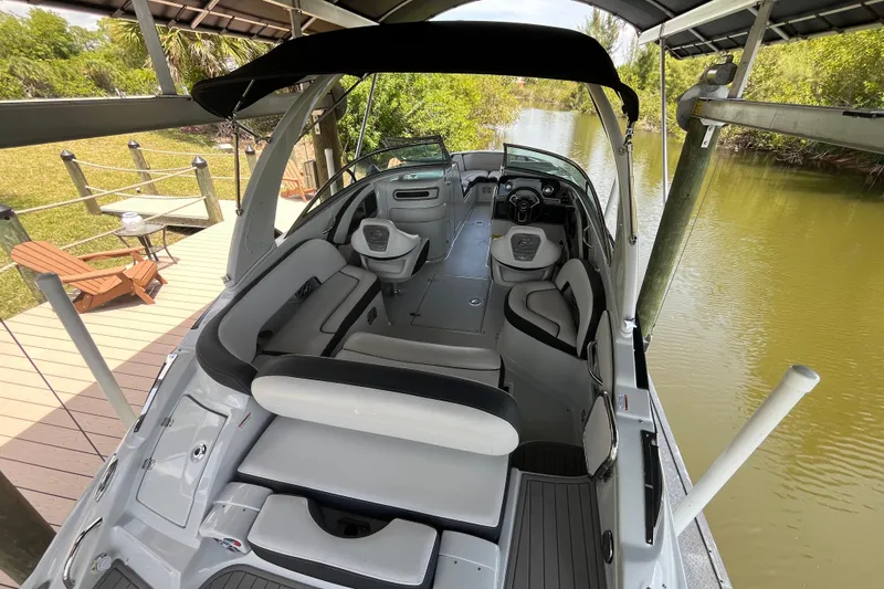 Slide: The Image of 2022 Crownline 260 XSS boat with sleek interior, docked by a serene river. - 5
