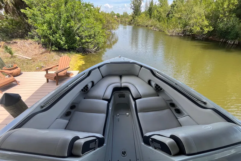 Slide: The Image of 2022 Crownline 260 XSS boat with spacious seating on a serene river. - 7