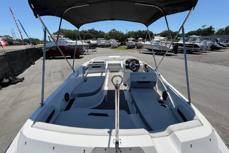 Slide: The Image of 2022 Hurricane SunDeck Sport 185 OB boat with canopy, parked in a marina. - 13