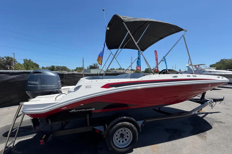 Slide: The Image of 2022 Hurricane SunDeck Sport 185 OB boat with Yamaha engine, red and white design, on trailer. - 2
