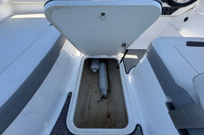 Slide: The Image of Open storage compartment on 2022 Hurricane SunDeck Sport 185 OB boat, showing interior space. - 28