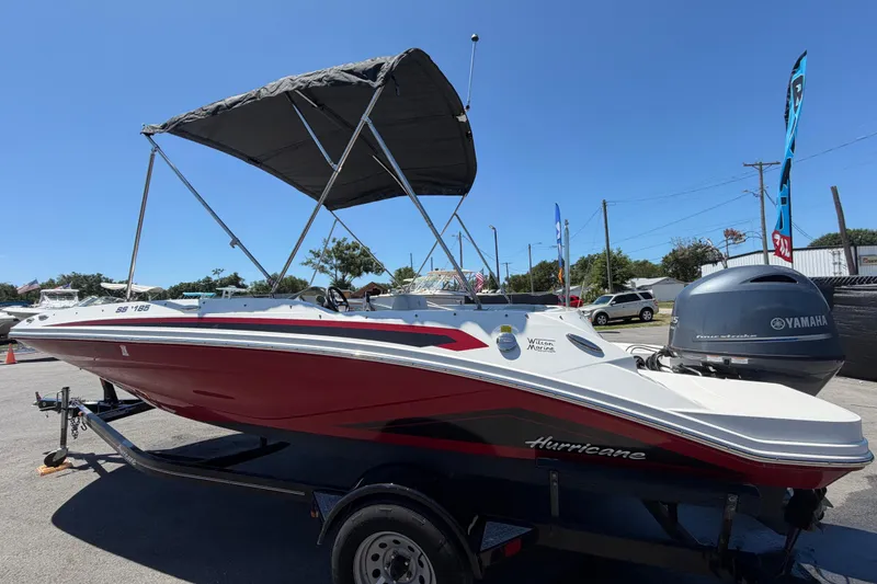 Slide: The Image of 2022 Hurricane SunDeck Sport 185 OB boat with Yamaha engine, parked outdoors under clear sky. - 5