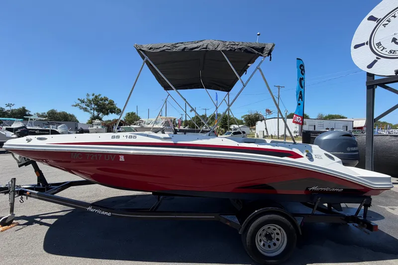 Slide: The Image of 2022 Hurricane SunDeck Sport 185 OB boat with red hull and canopy on trailer. - 6