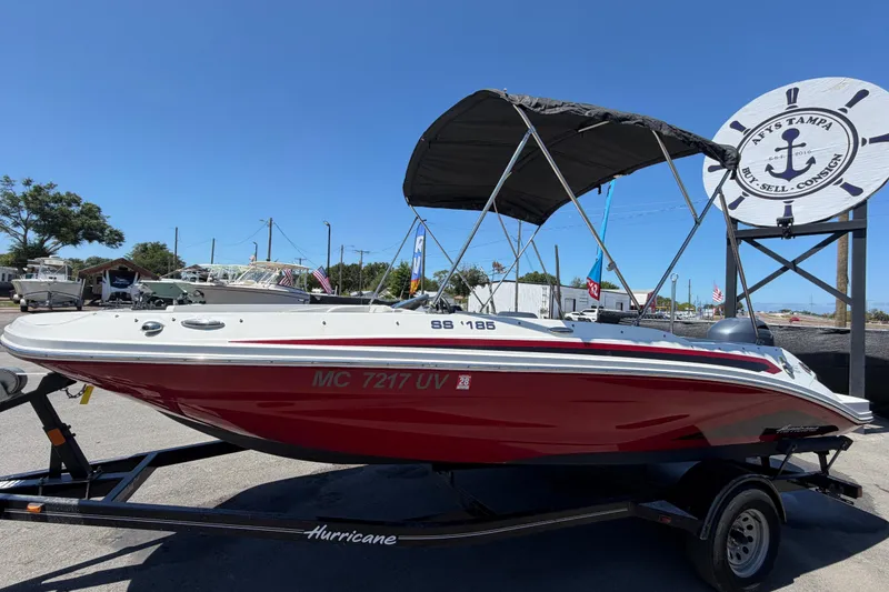 Slide: The Image of 2022 Hurricane SunDeck Sport 185 OB boat on trailer, displayed outdoors under clear blue sky. - 7
