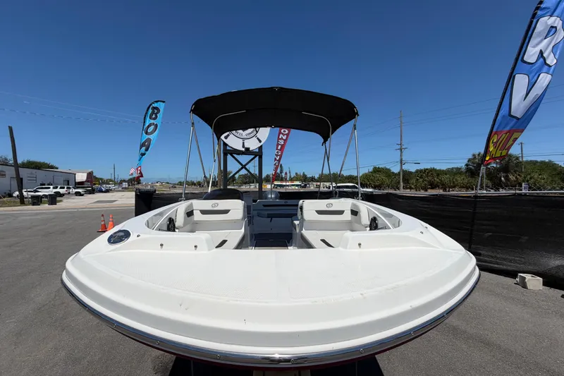 Slide: The Image of 2022 Hurricane SunDeck Sport 185 OB boat displayed outdoors with banners and clear sky. - 8