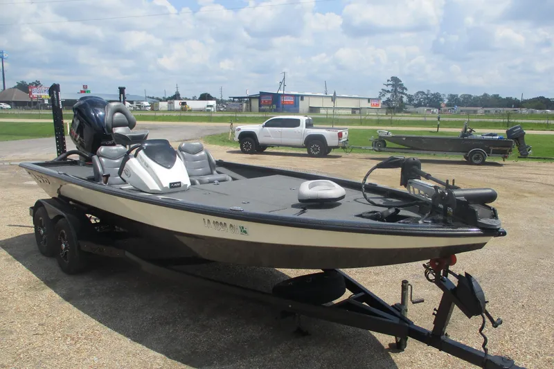 Slide: The Image of 2021 Avid 20XB boat on trailer, parked outdoors under a cloudy sky. - 2