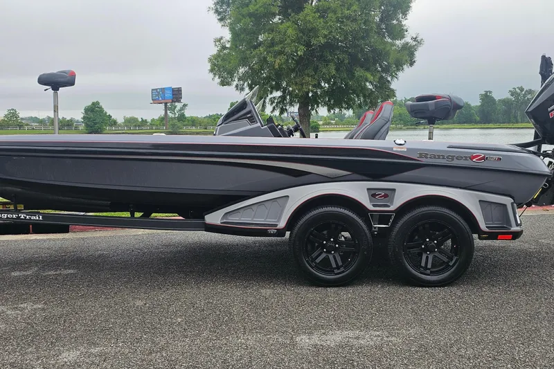 The Image of 2023 Ranger Z521R 55th Anniversary Limited Edition boat on trailer, parked near a lake. - 0