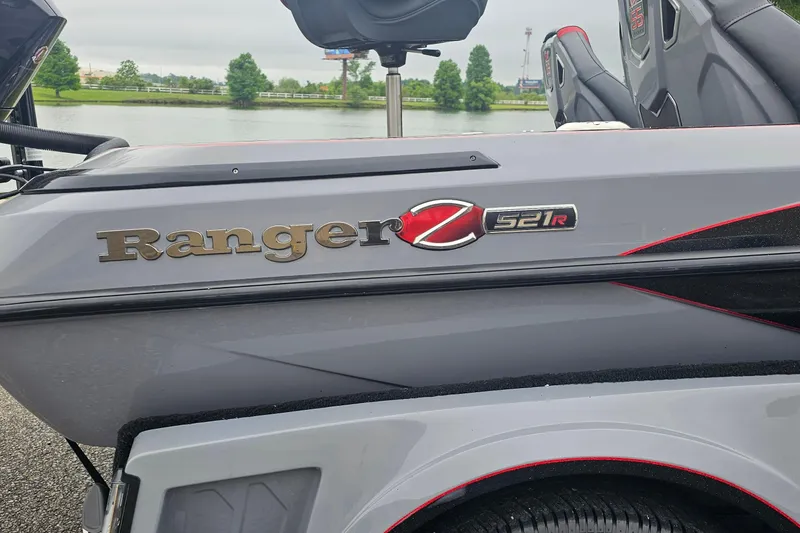 Slide: The Image of 2023 Ranger Z521R 55th Anniversary Limited Edition boat, side view near a lake. - 2