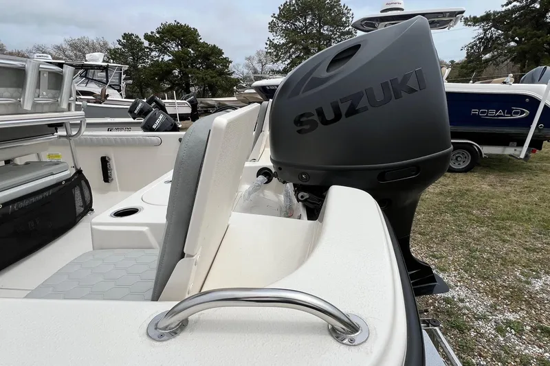 Slide: The Image of 2026 Carolina Skiff 21 LS boat with Suzuki outboard motor, parked outdoors. - 17