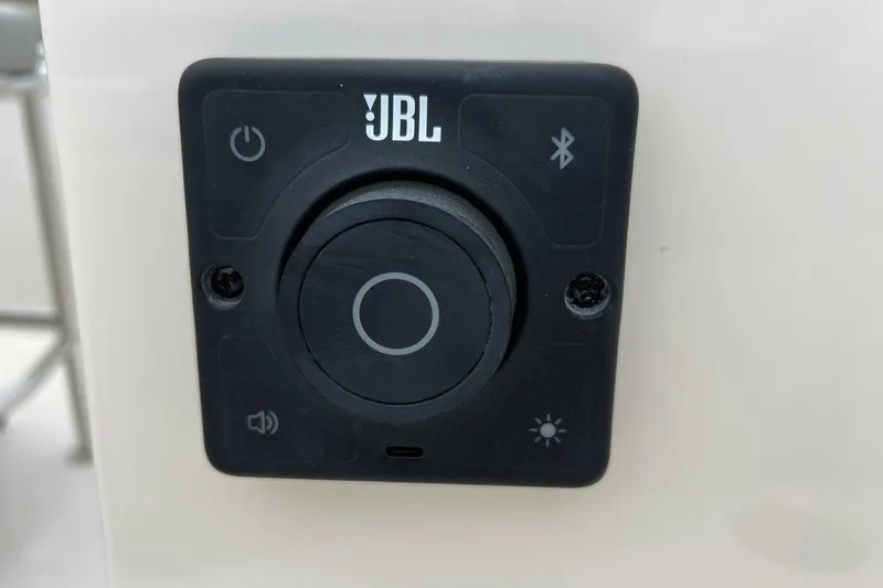 Slide: The Image of JBL control panel on 2026 Carolina Skiff 21 LS boat, featuring Bluetooth and power buttons. - 23