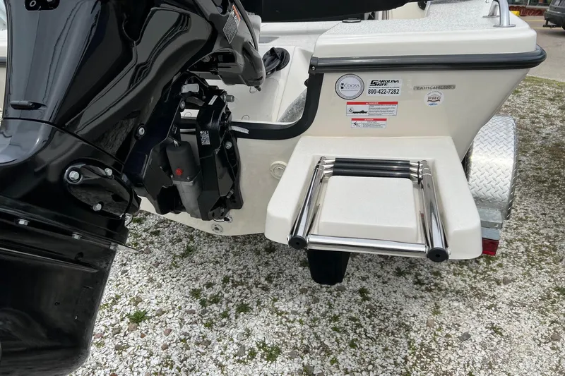 Slide: The Image of 2026 Carolina Skiff 21 LS boat with outboard motor and swim ladder on gravel surface. - 31