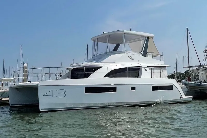 The Image of 2021 Leopard 43 Powercat yacht docked in a marina under clear blue skies. - 0