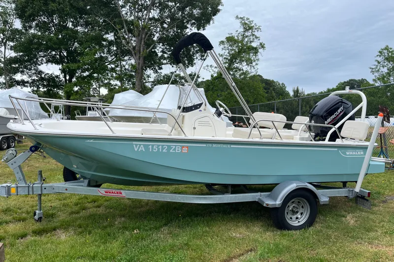 Slide: The Image of 2023 Boston Whaler 170 Montauk boat on trailer, parked on grass. - 11