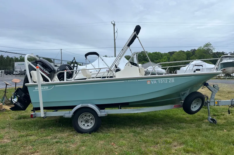 Slide: The Image of 2023 Boston Whaler 170 Montauk boat on trailer, parked outdoors. - 13
