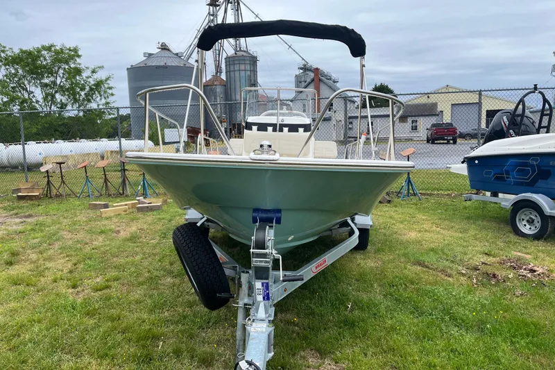 Slide: The Image of 2023 Boston Whaler 170 Montauk boat on trailer, parked outdoors near industrial buildings. - 15