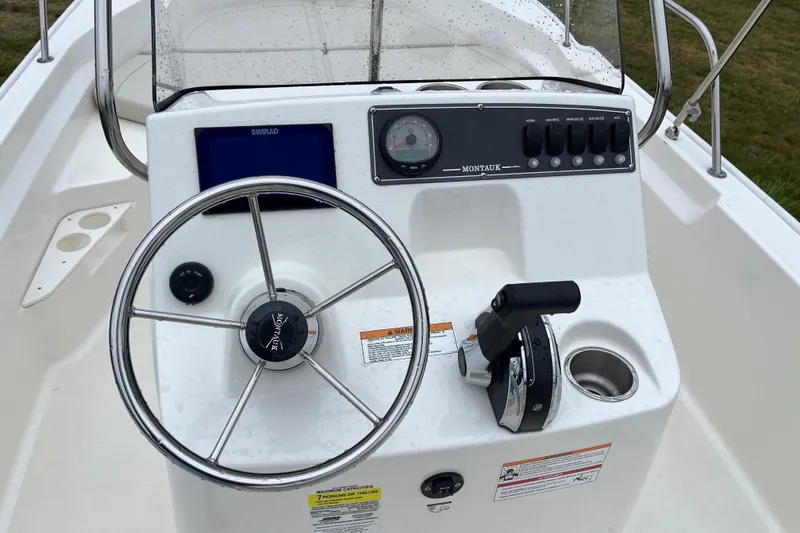 Slide: The Image of 2023 Boston Whaler 170 Montauk boat console with steering wheel and controls. - 3
