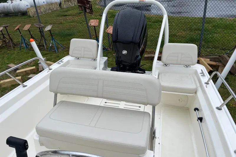 Slide: The Image of 2023 Boston Whaler 170 Montauk boat interior with seating and motor, showcasing sleek design. - 4