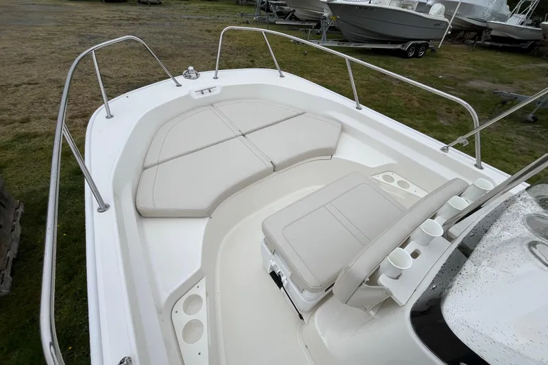 Slide: The Image of 2023 Boston Whaler 170 Montauk boat interior with cushioned seating and cup holders. - 7