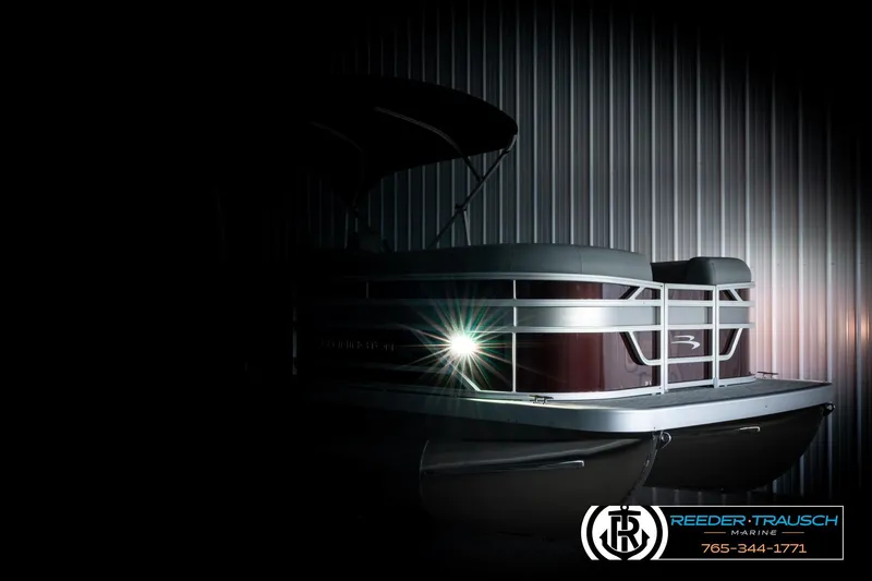 Slide: The Image of 2026 Bennington S20 Luxe pontoon boat in dimly lit showroom, showcasing sleek design. - 4