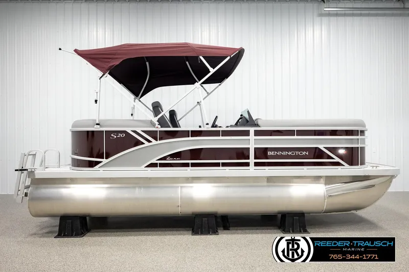 Slide: The Image of 2026 Bennington S20 Luxe pontoon boat with maroon canopy in showroom display. - 5