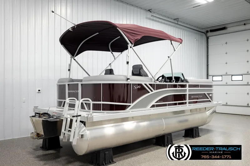 Slide: The Image of 2026 Bennington S20 Luxe pontoon boat in a showroom with maroon canopy. - 6