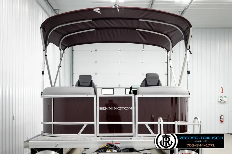 Slide: The Image of 2026 Bennington S20 Luxe pontoon boat in a showroom with canopy and seating. - 7