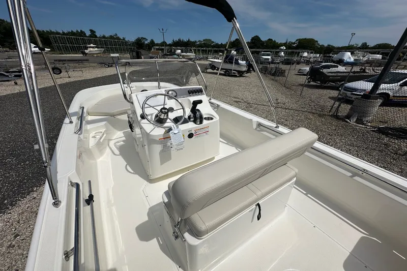 Slide: The Image of The image shows a 2027 Boston Whaler 170 Montauk boat with an open cockpit and beige seating area. - 4