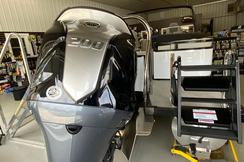 Slide: The Image of 2026 Avalon LSZ 2385 QL pontoon boat with powerful 200 HP engine in showroom. - 21