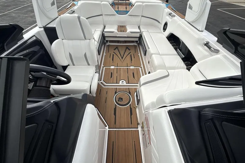Slide: The Image of 2024 Supra SA 550 boat interior with white seating and wood flooring. - 12