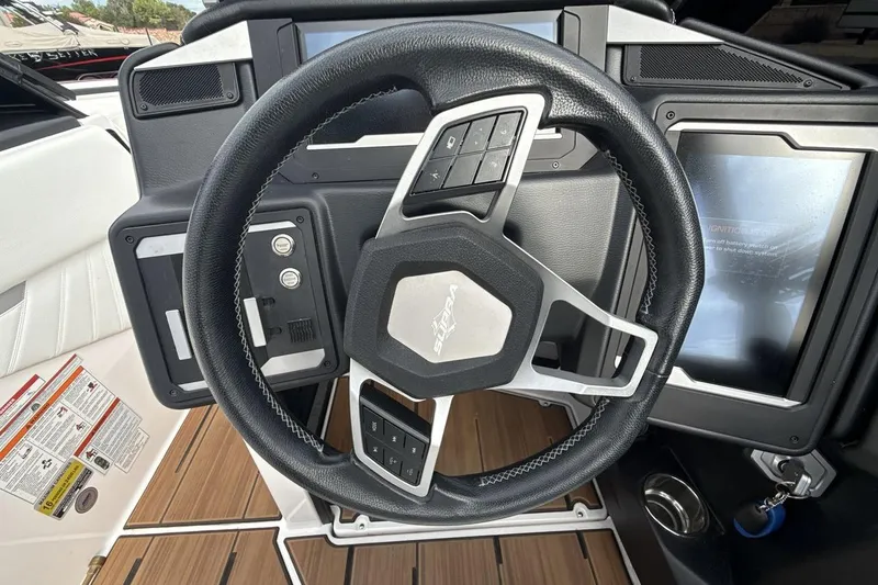 Slide: The Image of Steering wheel and dashboard of 2024 Supra SA 550 boat, featuring modern controls and display. - 14
