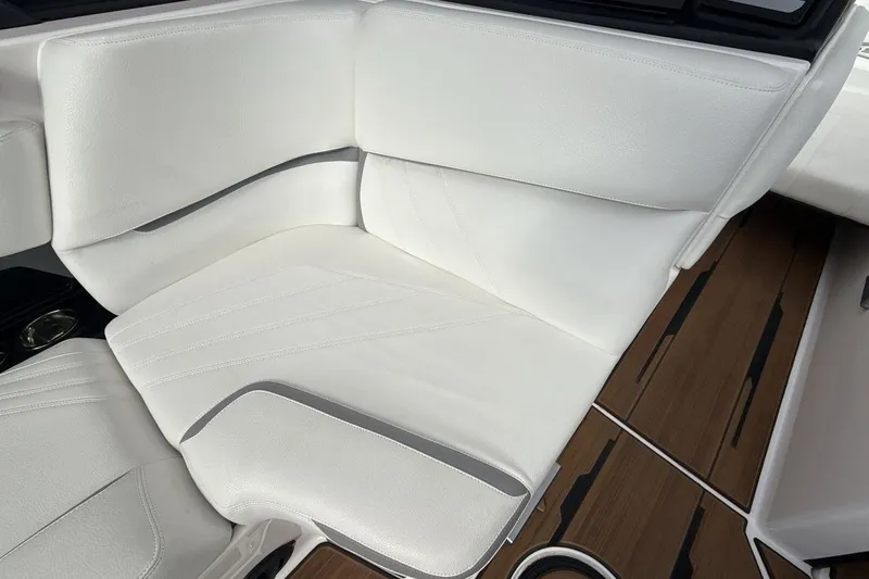 Slide: The Image of 2024 Supra SA 550 boat interior with white leather seating and wood flooring. - 17