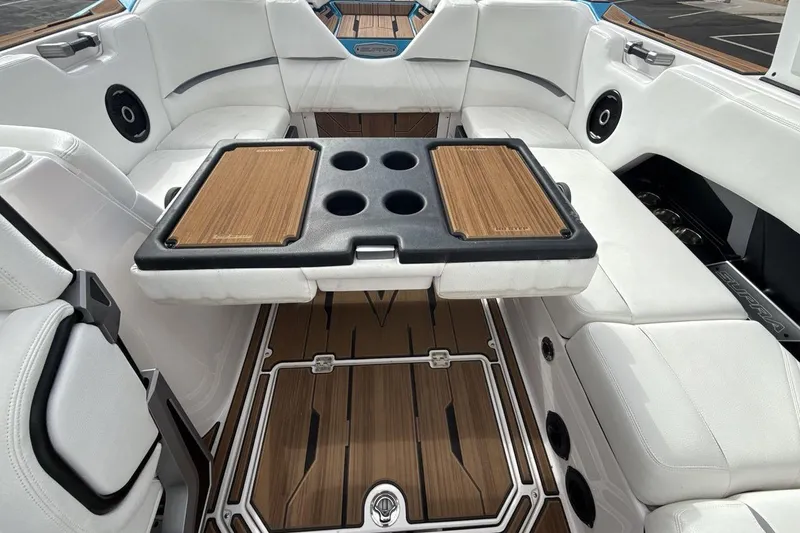 Slide: The Image of 2024 Supra SA 550 boat interior with white seating and wooden table. - 23
