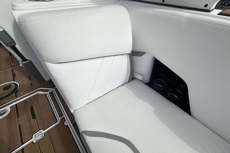 Slide: The Image of 2024 Supra SA 550 boat interior with white leather seating and cup holders. - 24