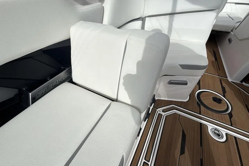 Slide: The Image of 2024 Supra SA 550 boat interior with white seating and wood-style flooring. - 25