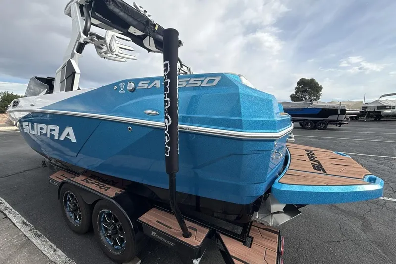 Slide: The Image of 2024 Supra SA 550 boat in vibrant blue, parked on a trailer. - 3