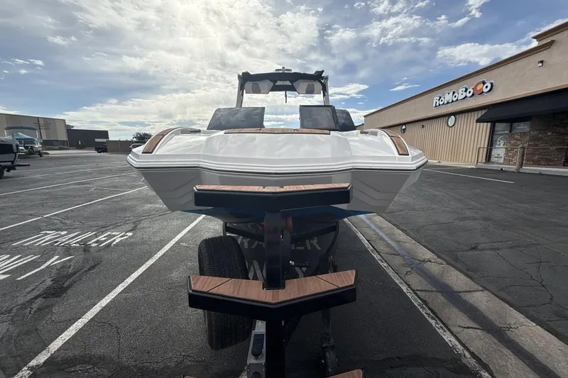 Slide: The Image of 2024 Supra SA 550 boat on trailer in parking lot, cloudy sky background. - 8