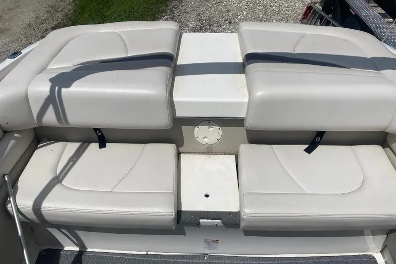 Slide: The Image of 2005 Chaparral 210 SSi boat interior with white cushioned seating and storage area. - 4