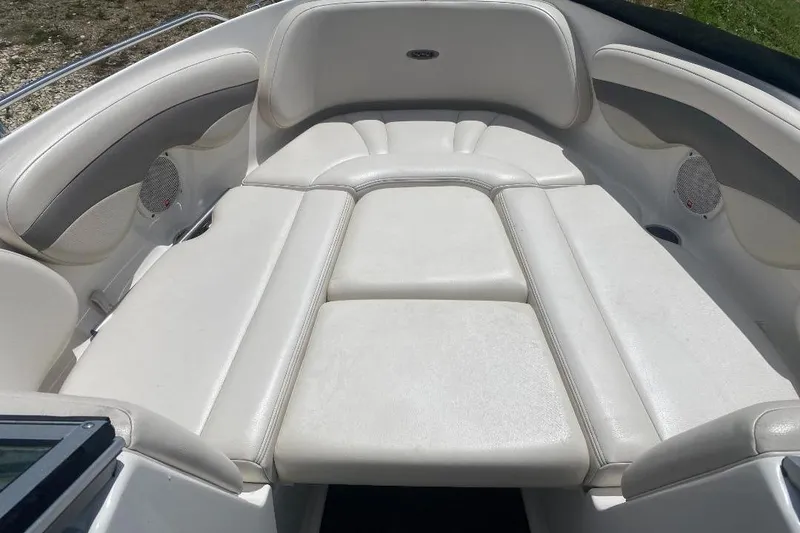 Slide: The Image of 2005 Chaparral 210 SSi boat interior with white cushioned seating and built-in speakers. - 8