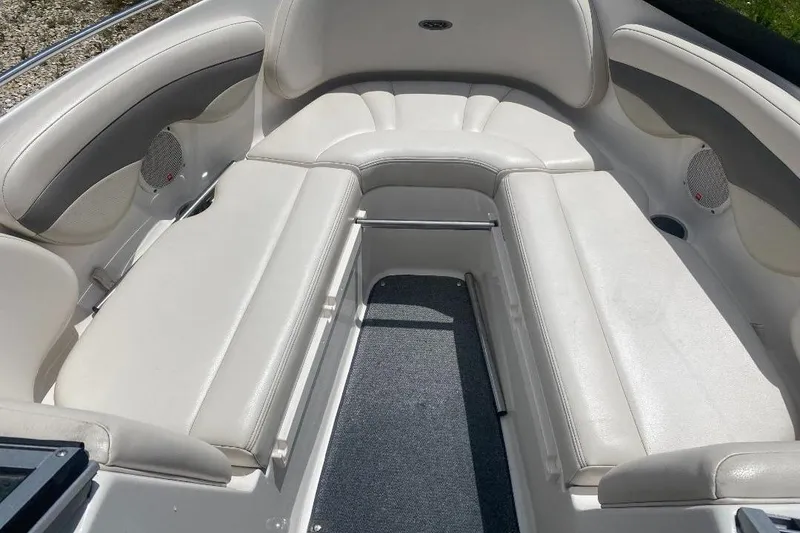 Slide: The Image of 2005 Chaparral 210 SSi boat interior with white cushioned seating and carpeted floor. - 9