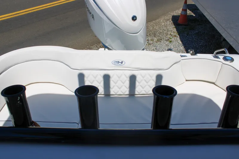 Slide: The Image of 2026 Sea Hunt Ultra 219 boat interior with white seating and rod holders. - 14