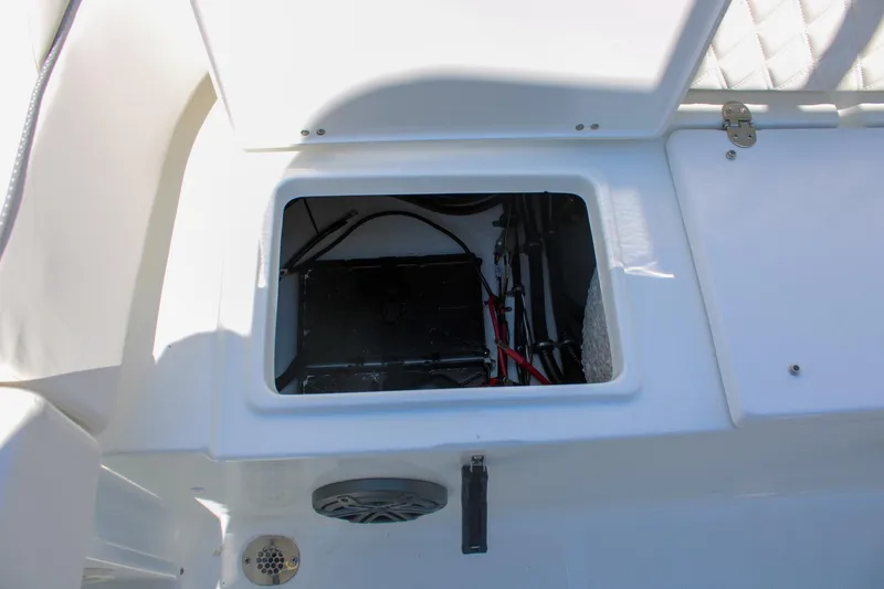 Slide: The Image of Open storage compartment on 2026 Sea Hunt Ultra 219 boat, showing wiring and components. - 16