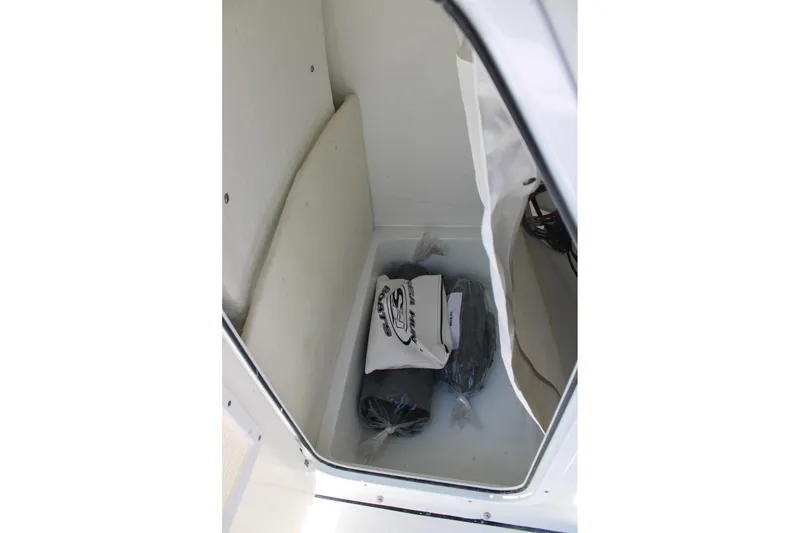 Slide: The Image of Storage compartment inside 2026 Sea Hunt Ultra 219 boat, featuring branded gear. - 30