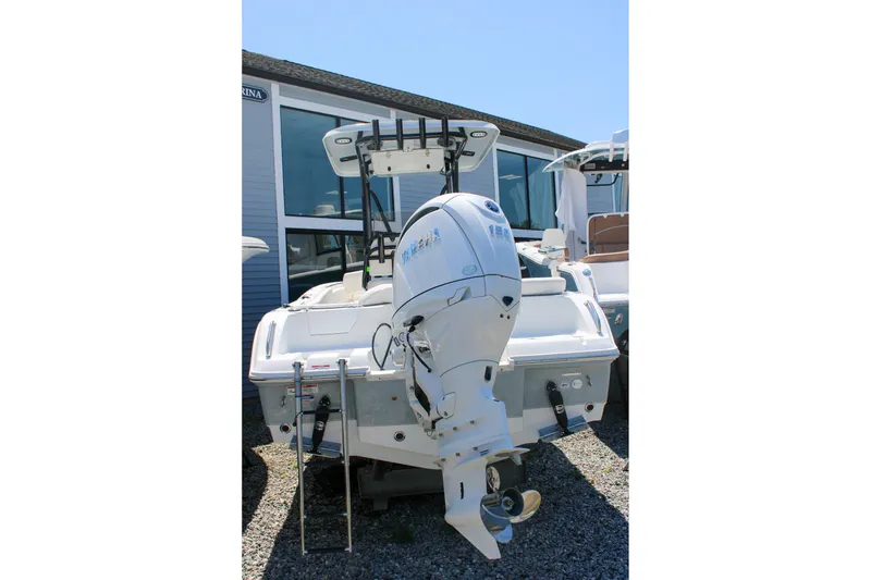 Slide: The Image of 2026 Sea Hunt Ultra 219 boat with outboard motor, parked outdoors. - 31