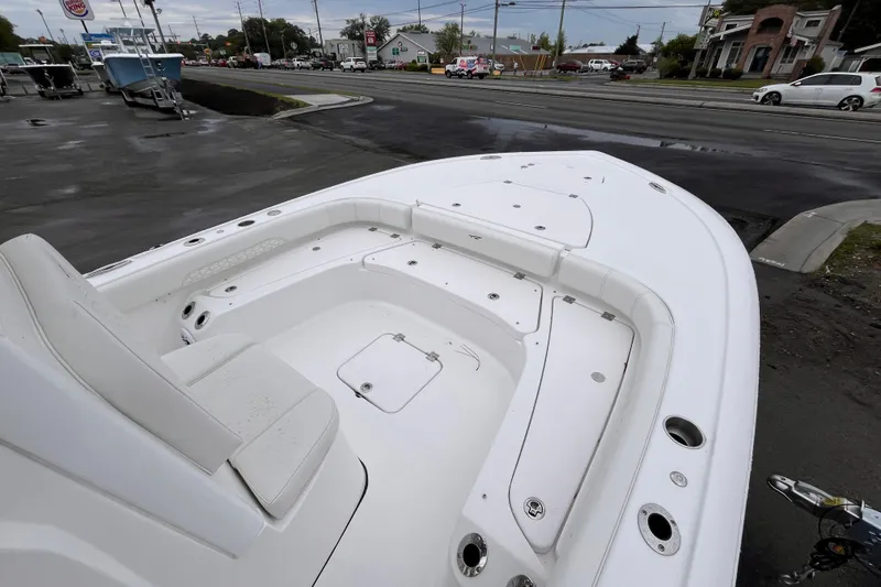 Slide: The Image of 2026 Tidewater 2500 Carolina Bay boat with spacious seating and storage, parked near a road. - 10
