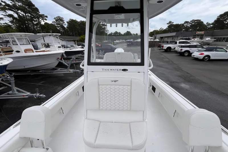 Slide: The Image of 2026 Tidewater 2500 Carolina Bay boat interior with white seating, parked in a dealership lot. - 11